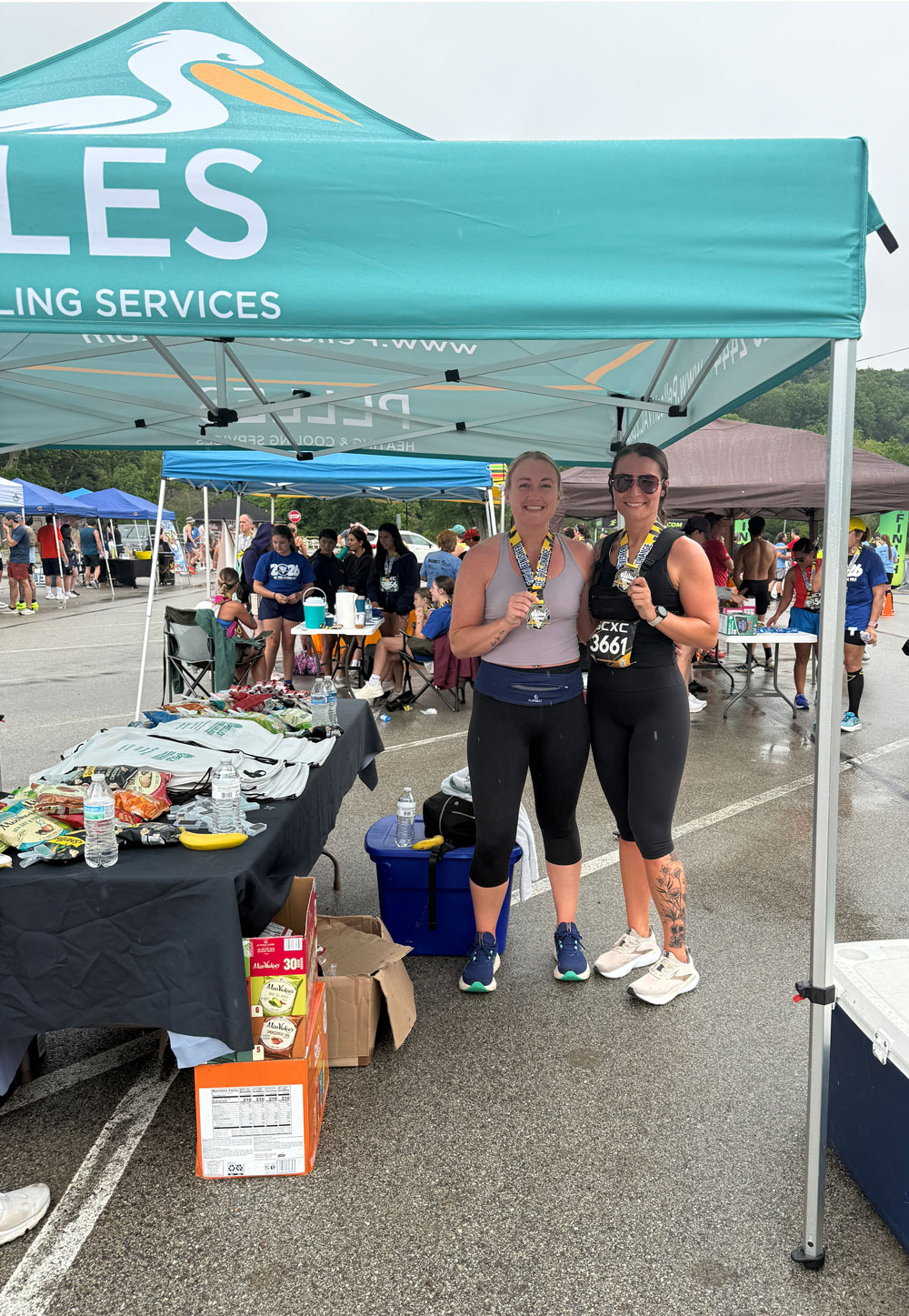 Chelsea Febinger and her friend show their medals under the Pelles tent
